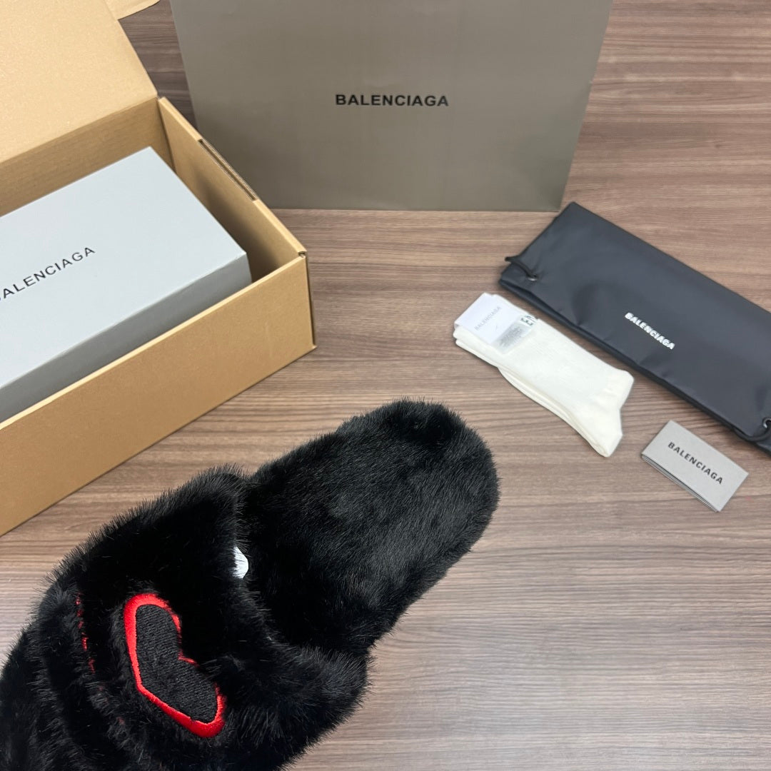 Black plush slide sandals with red logo detail, open-toe view