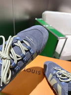 Blue-gray suede lace-up sneaker close-up, green geometric panel and side branding tabs