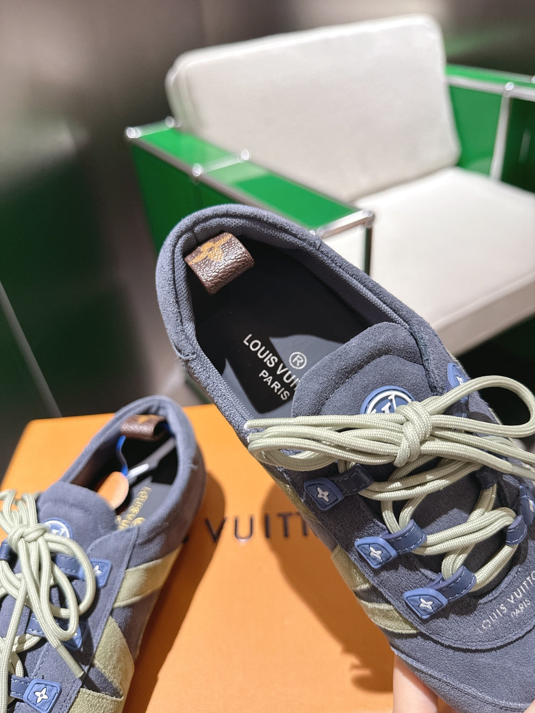 Blue-gray lace-up sneaker showing padded collar and light laces, with logo on tongue