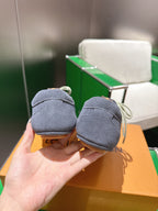 Unisex blue-gray lace-up sneakers, heel view held in hand