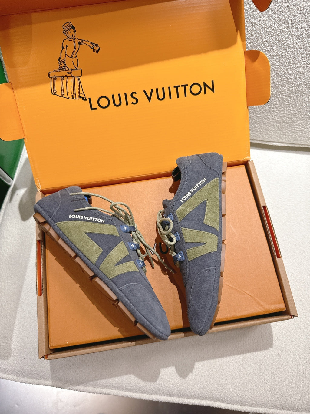 Unisex blue-gray lace-up sneakers with green geometric side panels, paired in shoebox