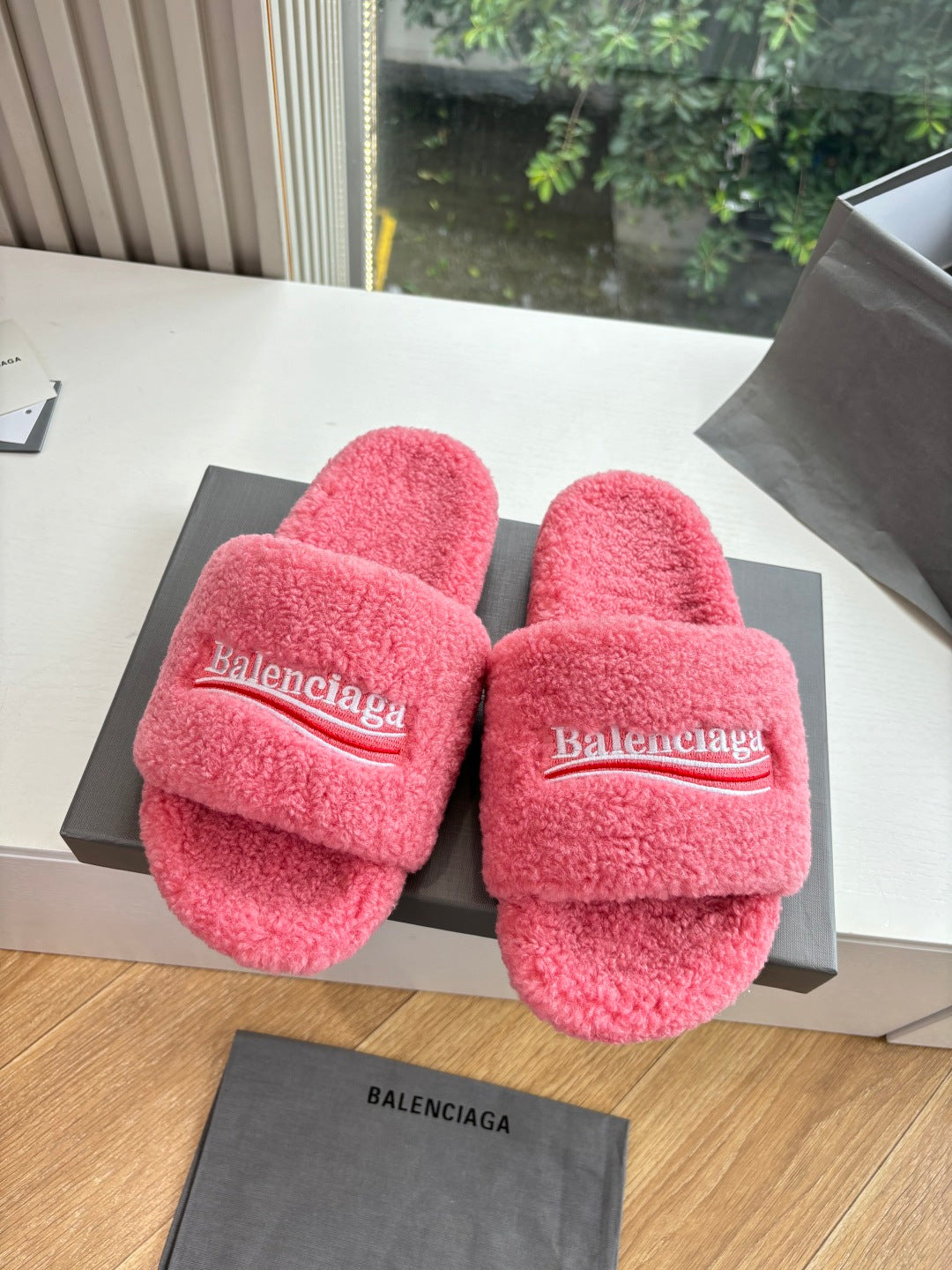 Balenciaga pink plush slide sandals with wide logo strap, front view on box