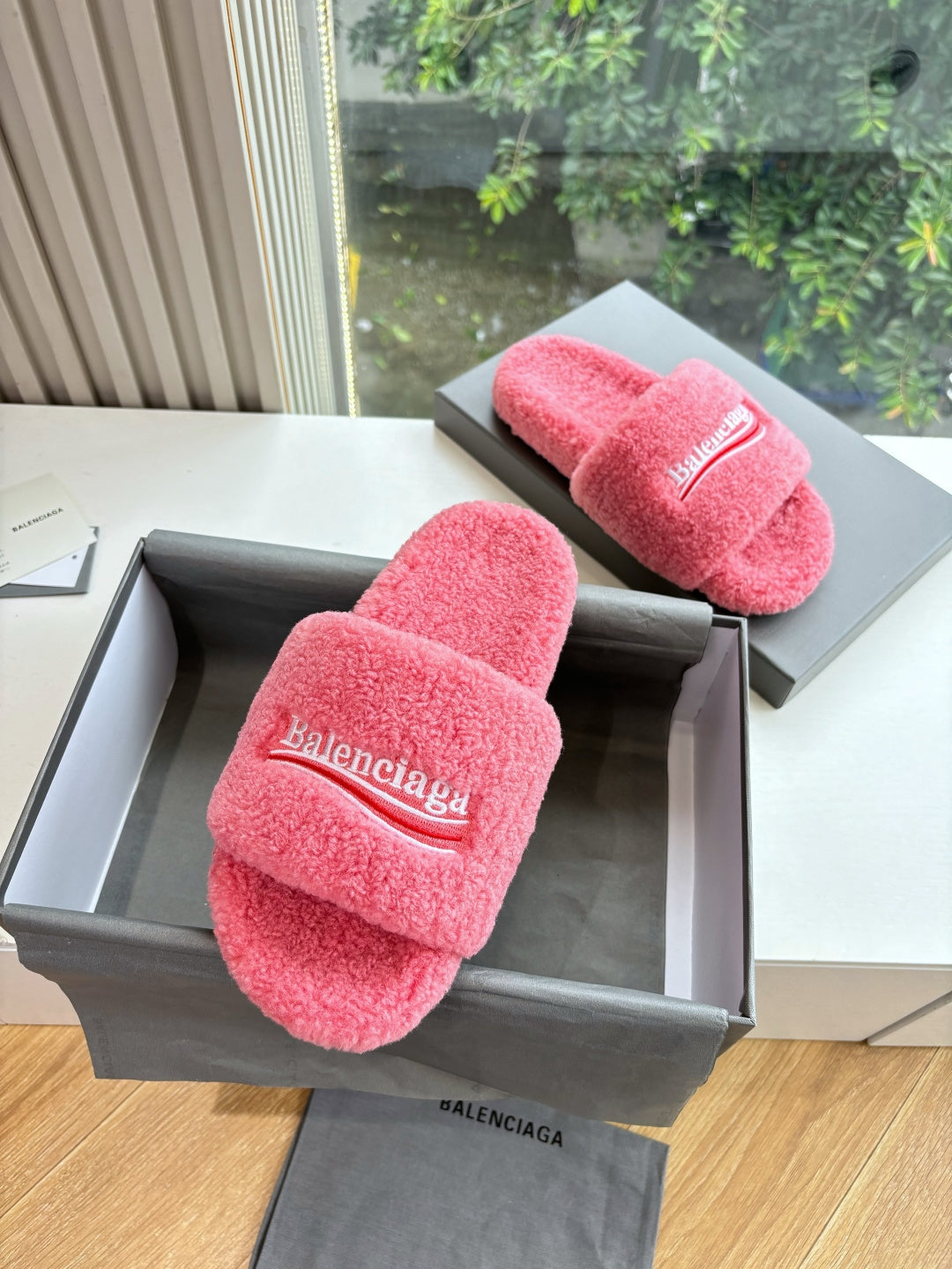 Balenciaga pink plush slide sandals with wide logo band, pair resting in box
