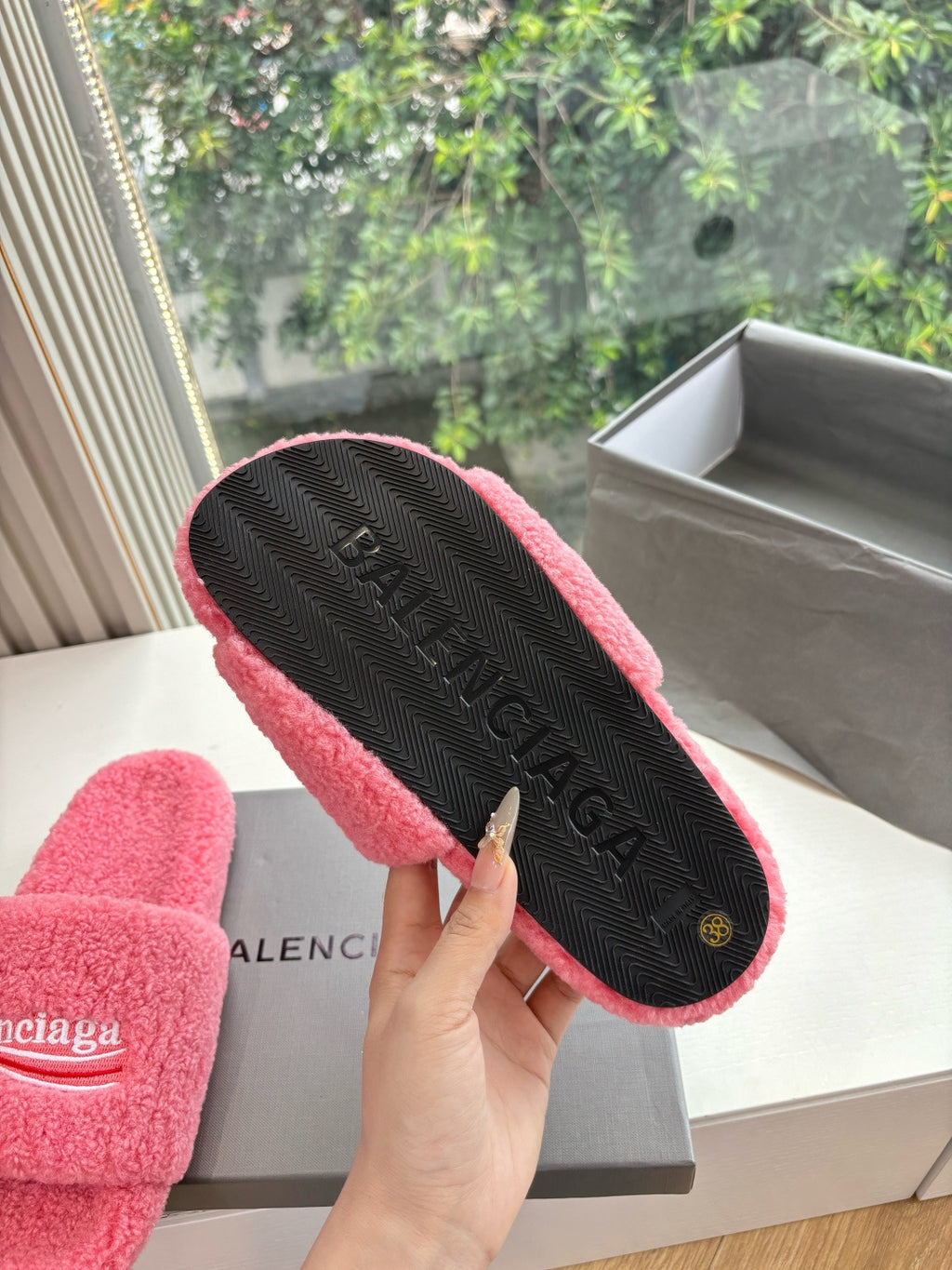 Balenciaga slide sandal outsole with black textured tread and logo, pink lining