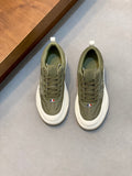 Olive low-top sneakers with white rubber sole, lace-up front, logo patch detail