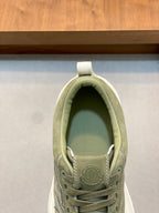 Olive sneaker tongue and laces close-up with circular emblem logo