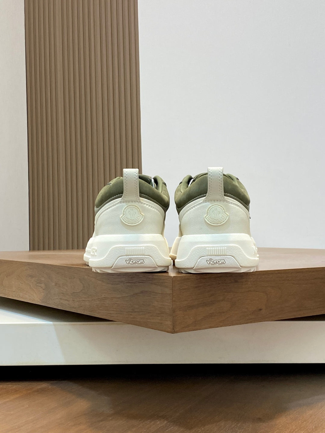 Olive sneakers viewed from back with white soles and heel branding