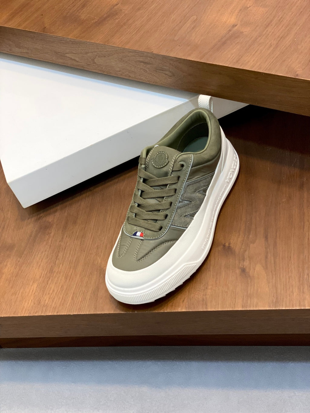 Olive low-top sneakers with white rubber sole, lace-up closure, and side logo