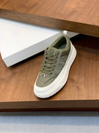 Olive low-top sneakers with white rubber sole, lace-up closure, and side logo