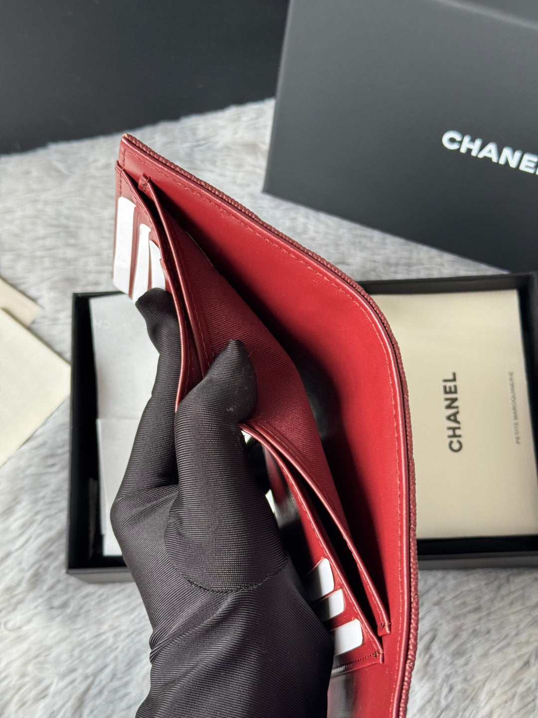Small red wallet bag open with inner card slots and gold-toned trim
