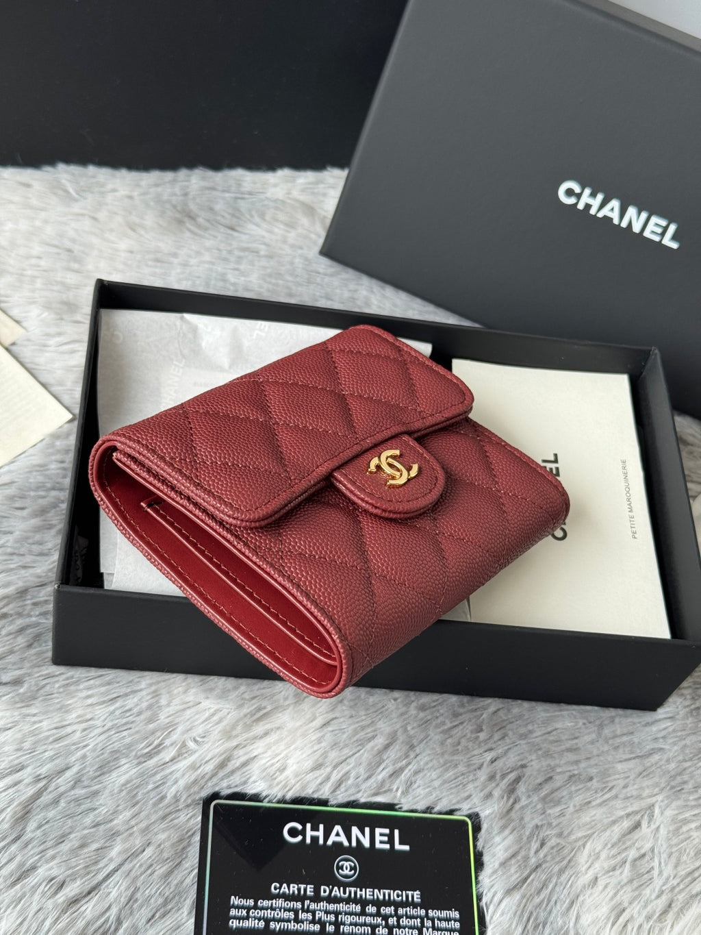 Small quilted red wallet bag shown at an angle with gold CC clasp