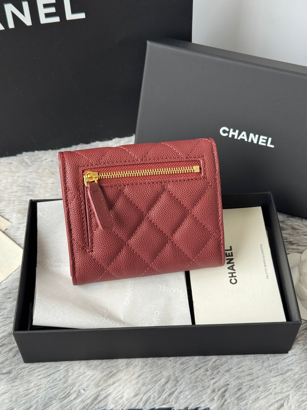 Small quilted red wallet bag with front flap and gold zip pull