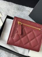 Small quilted red wallet bag detail with gold zipper and front pocket tab