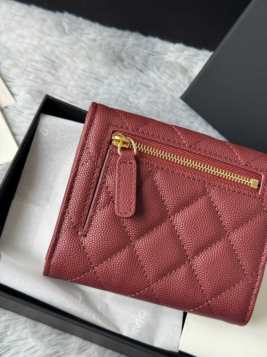 Small quilted red wallet bag detail with gold zipper and front pocket tab