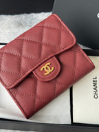 Small quilted red wallet bag close-up with gold CC flap clasp
