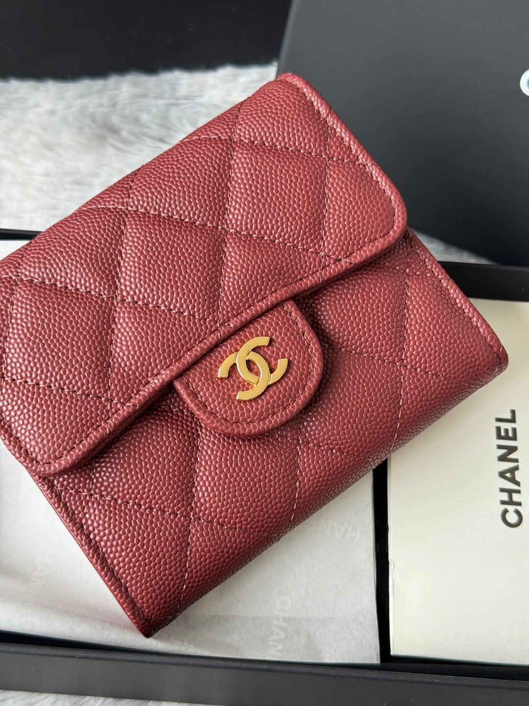 Small quilted red wallet bag close-up with gold CC flap clasp