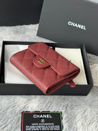 Small quilted red wallet bag with flap, gold CC logo, and rolled edges