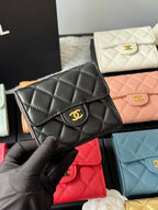 Black quilted small flap bag with gold-tone CC logo and curved flap