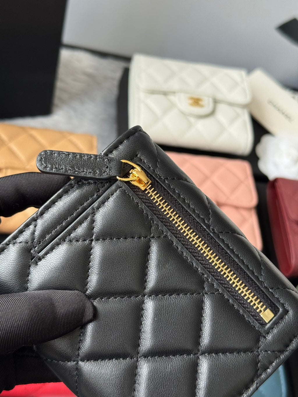 Black quilted small bag with front zip pocket and gold-tone zipper pull