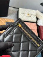 Black quilted small bag with front zip pocket and gold-tone zipper pull