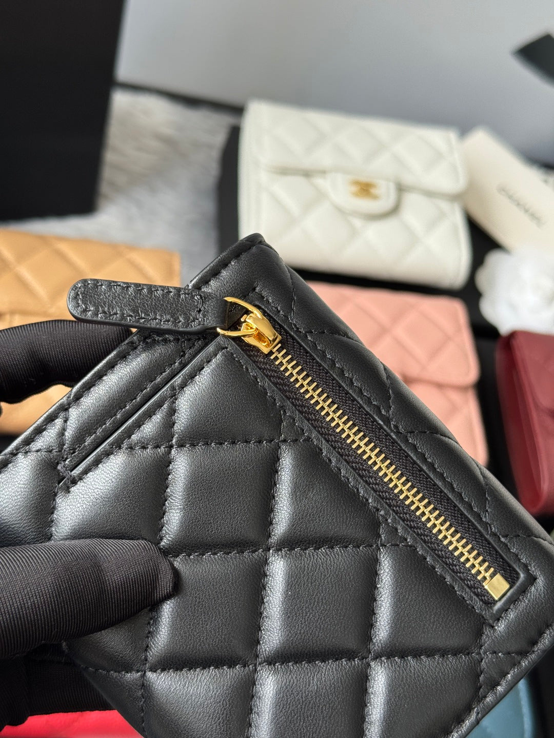 Black quilted small bag with front zip pocket and gold-tone zipper pull