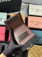Brown leather-look card wallet with gold-tone rails and CHANEL on exterior