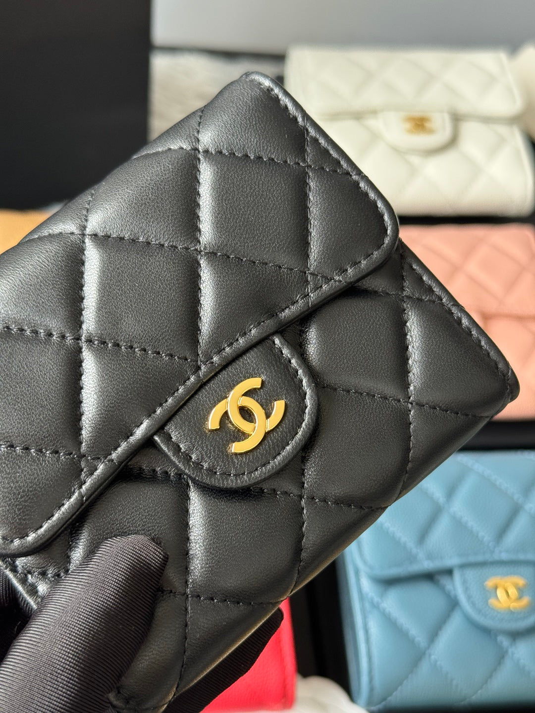 Black quilted small flap bag close-up with gold CC emblem