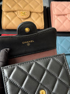 Black small card wallet with CHANEL logo, round button, and quilted front