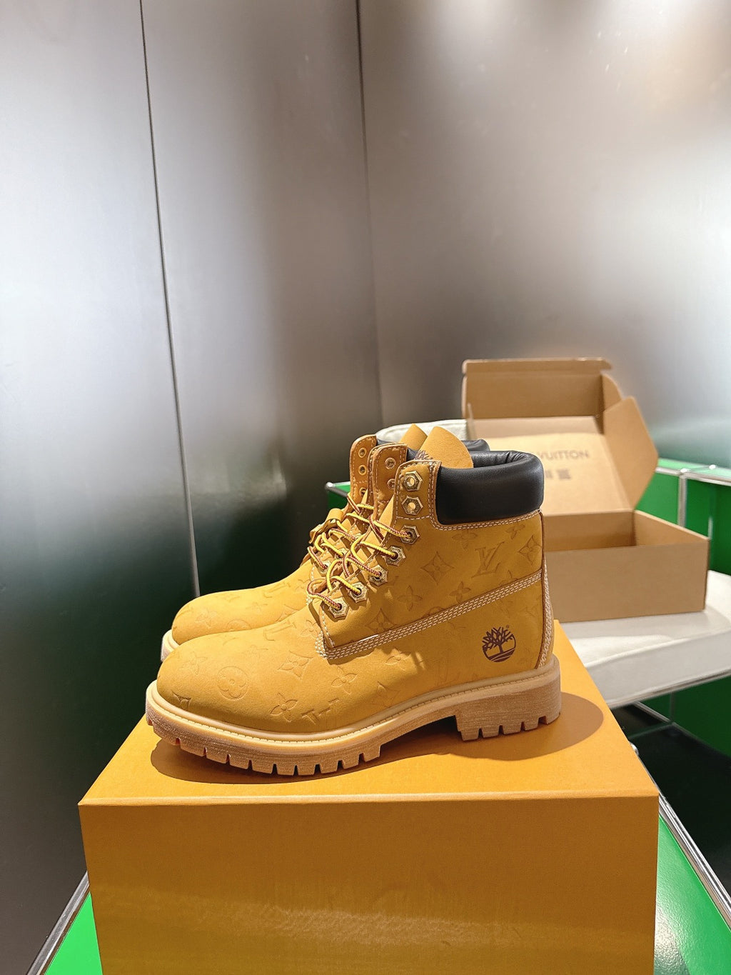 Tan lace-up boot with embossed pattern and dark upper collar, standing on box
