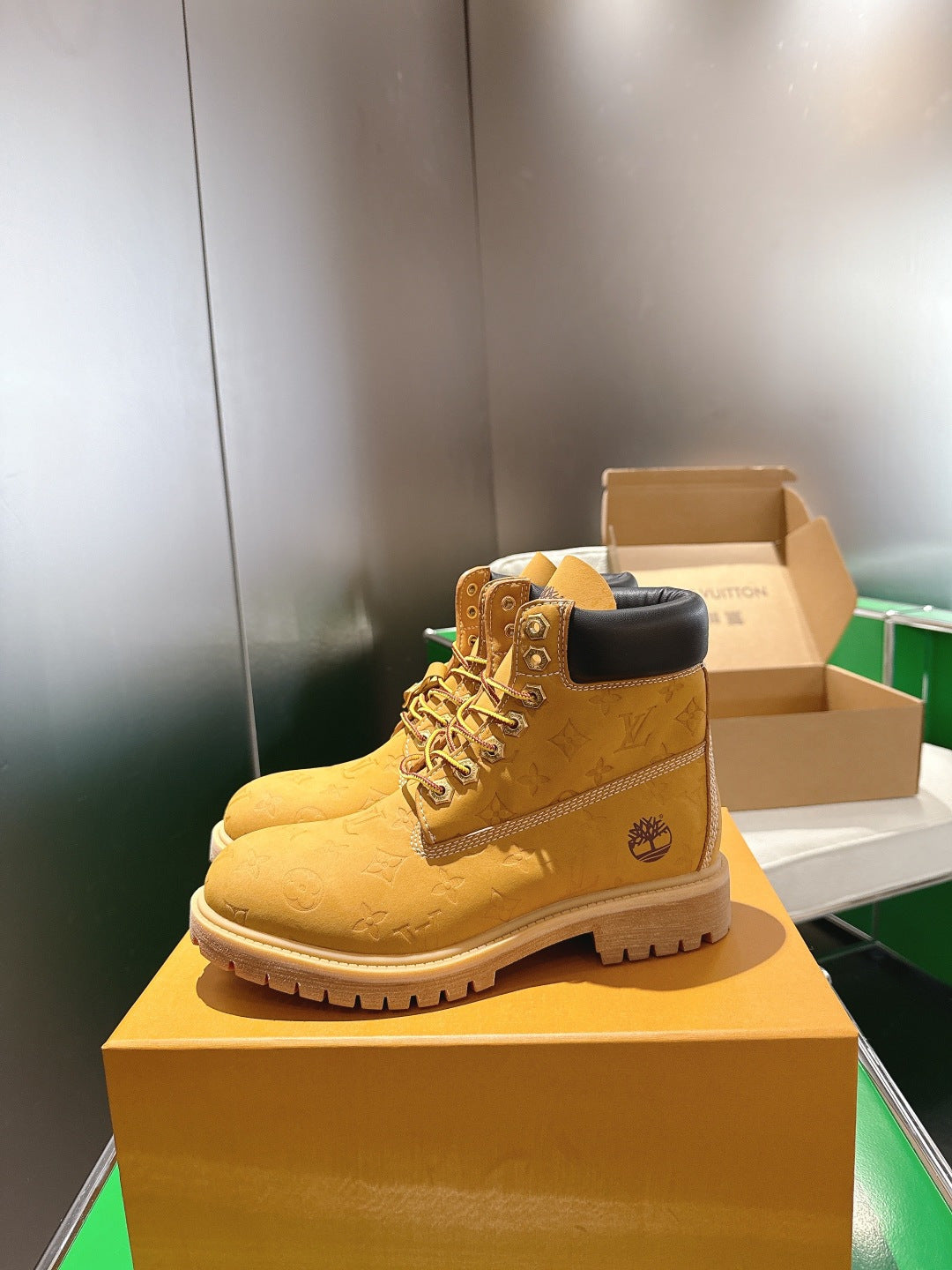 Tan lace-up boot with embossed pattern and dark upper collar, standing on box