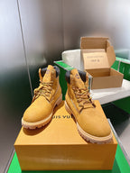 Tan lace-up boots with embossed logo texture, dark heel collar, shown side-by-side