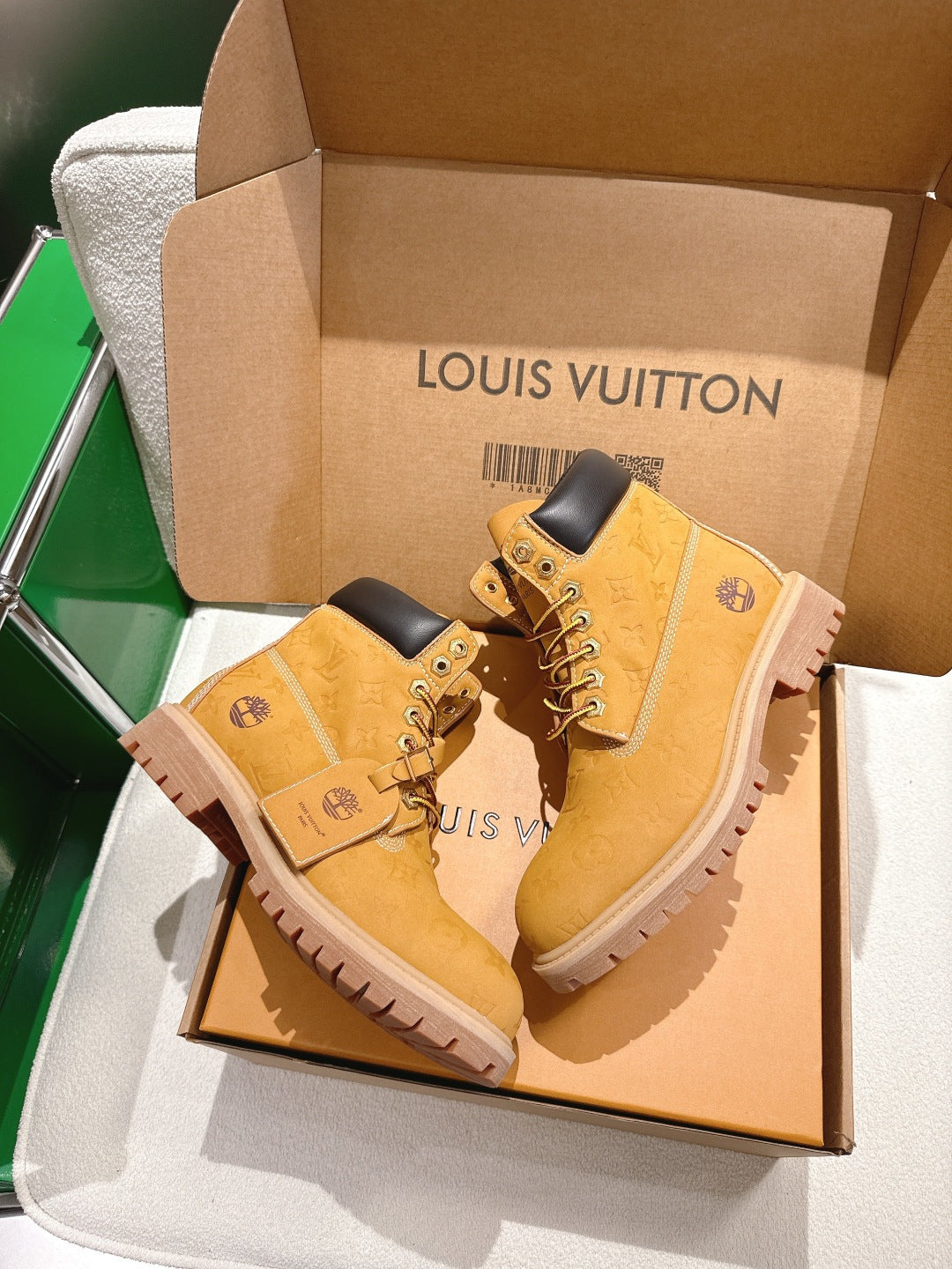 Tan lace-up boots with embossed texture and dark collar, in open shoe box