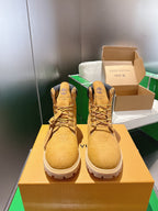 Tan lace-up boots with embossed pattern and dark ankle collar, on display
