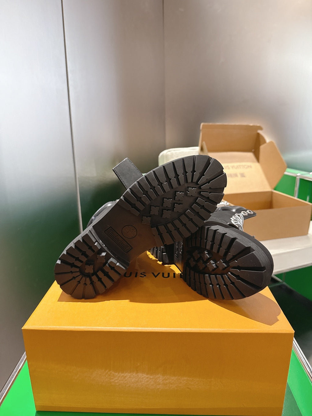 Louis Vuitton unisex black boots showing treaded outsoles on box