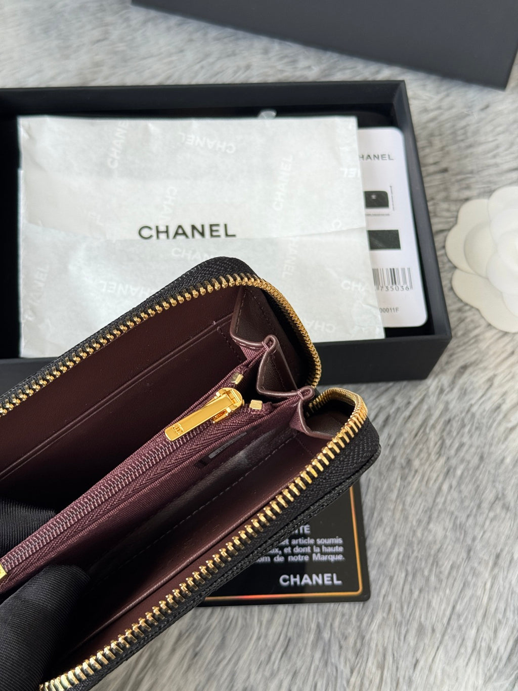 Small bag interior close-up with CHANEL stamp, zipper pull, and card holder