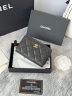 Small quilted black leather pouch with CHANEL logo, wrist strap, and gold hardware