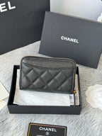 Quilted small bag front view with gold-tone zipper and CC logo on black leather