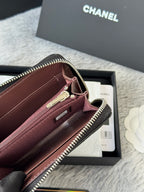 Small bag with maroon interior, zip pocket, gold-tone zipper, black edge trim