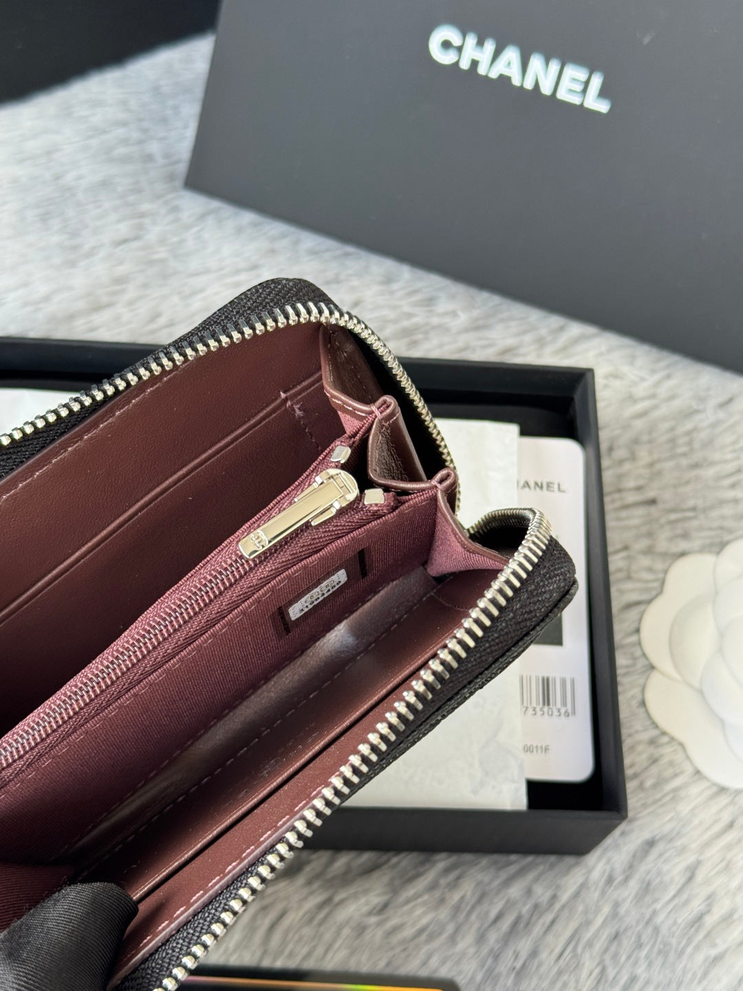 Small bag with maroon interior, zip pocket, gold-tone zipper, black edge trim
