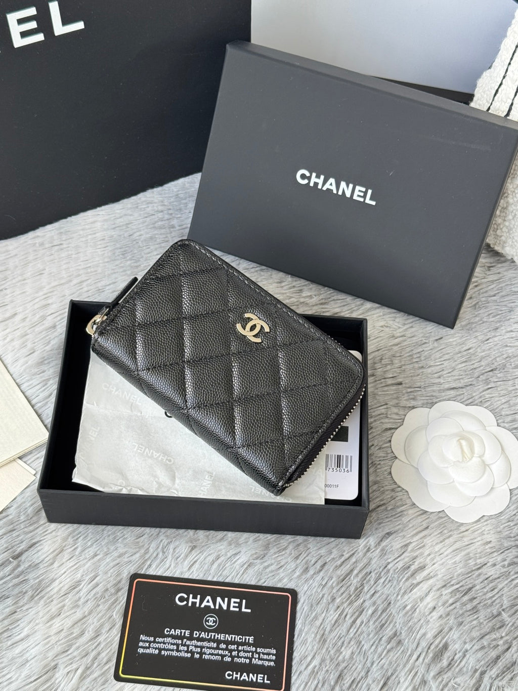 Chanel quilted small bag with top zip and chain strap, dark black, front view.