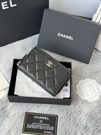 Chanel quilted small bag with top zip and chain strap, dark black, front view.