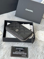 Chanel quilted small bag with zip closure and chain strap, dark black, side view.