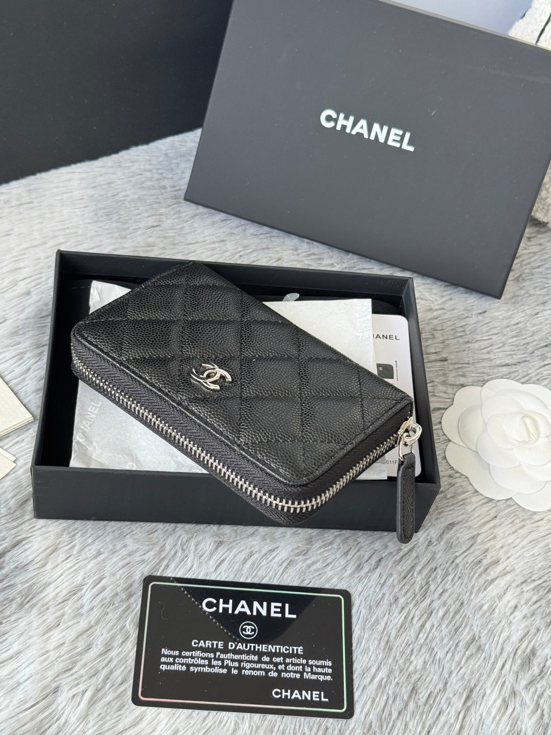 Chanel quilted small bag with zip closure and chain strap, dark black, side view.