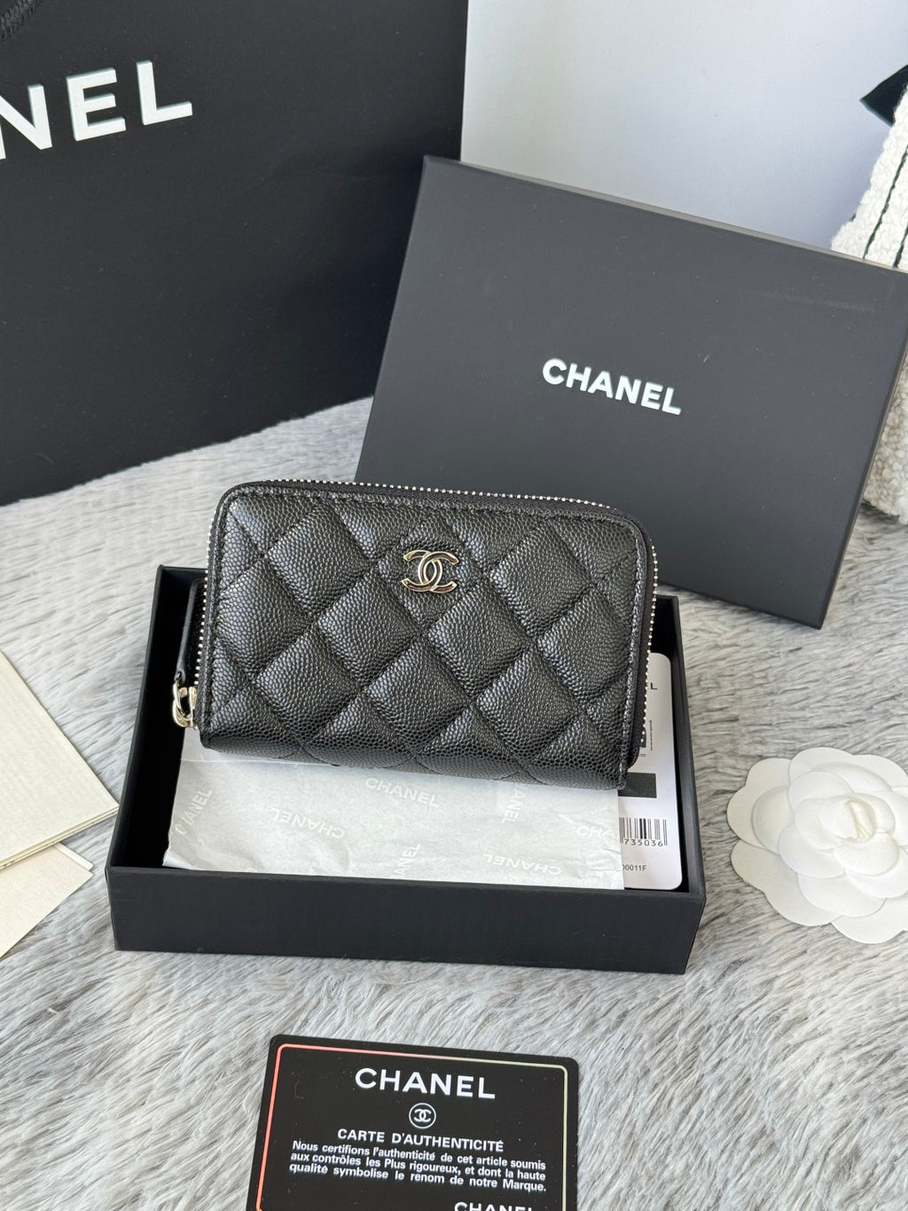 Chanel quilted small bag with front emblem and zip closure, dark black.