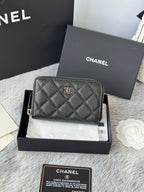 Chanel quilted small bag with front emblem and zip closure, dark black.