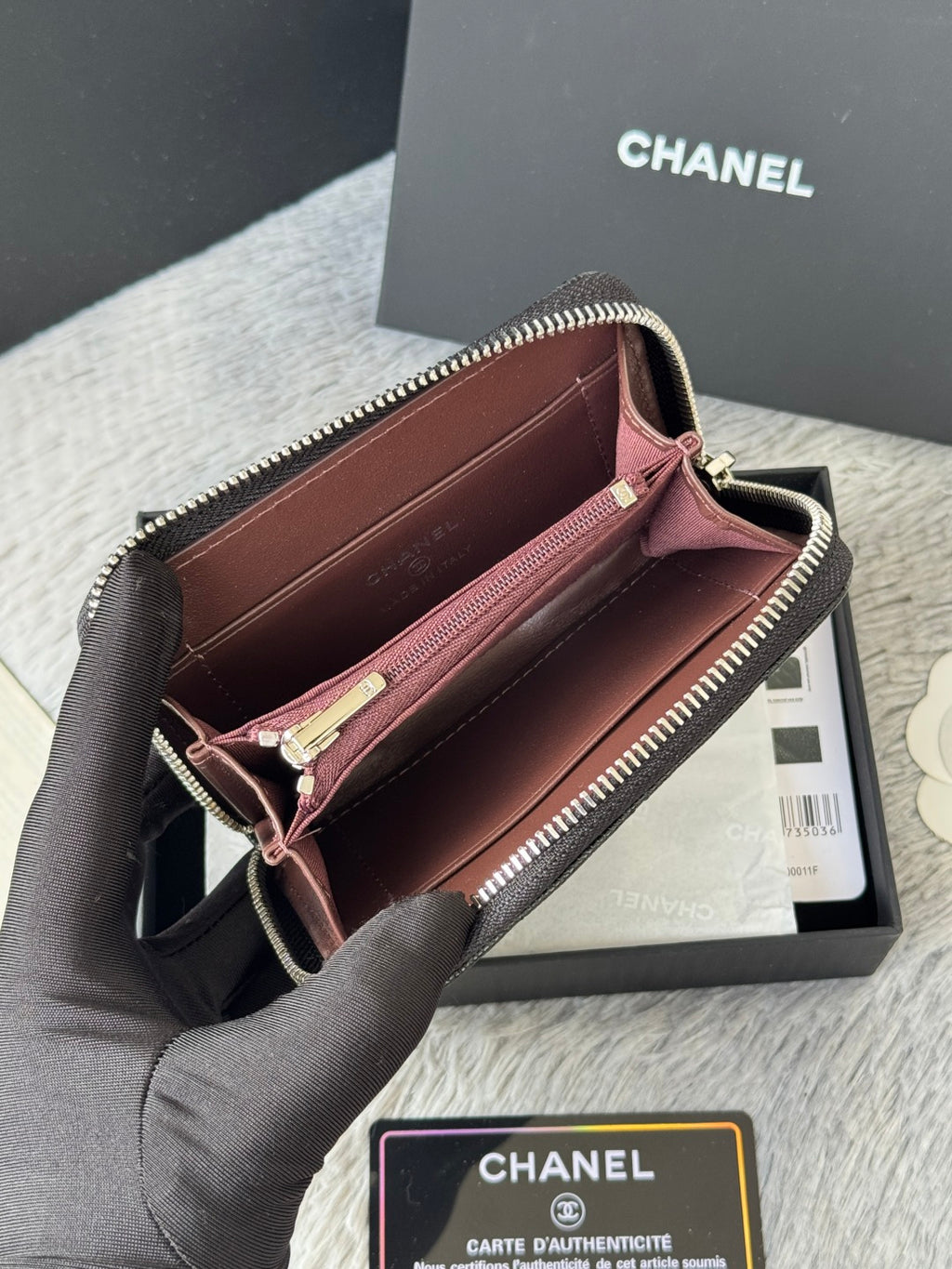 Chanel small bag with zip closure, maroon interior lining, dark outer leather.