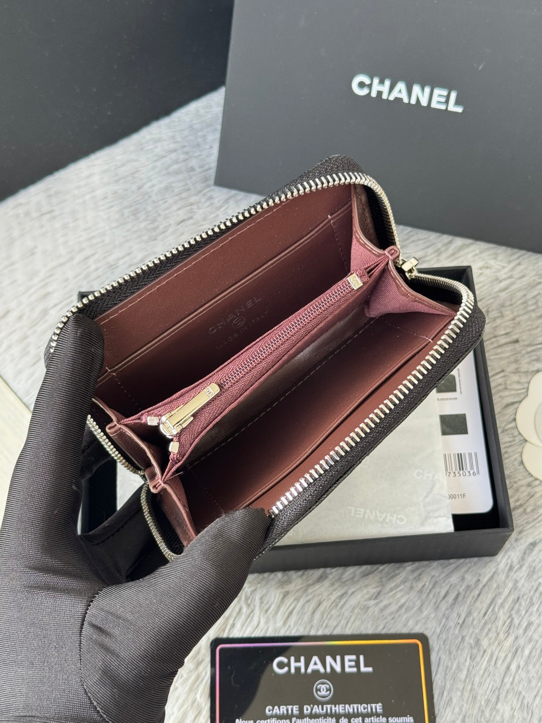 Chanel small bag with zip closure, maroon interior lining, dark outer leather.