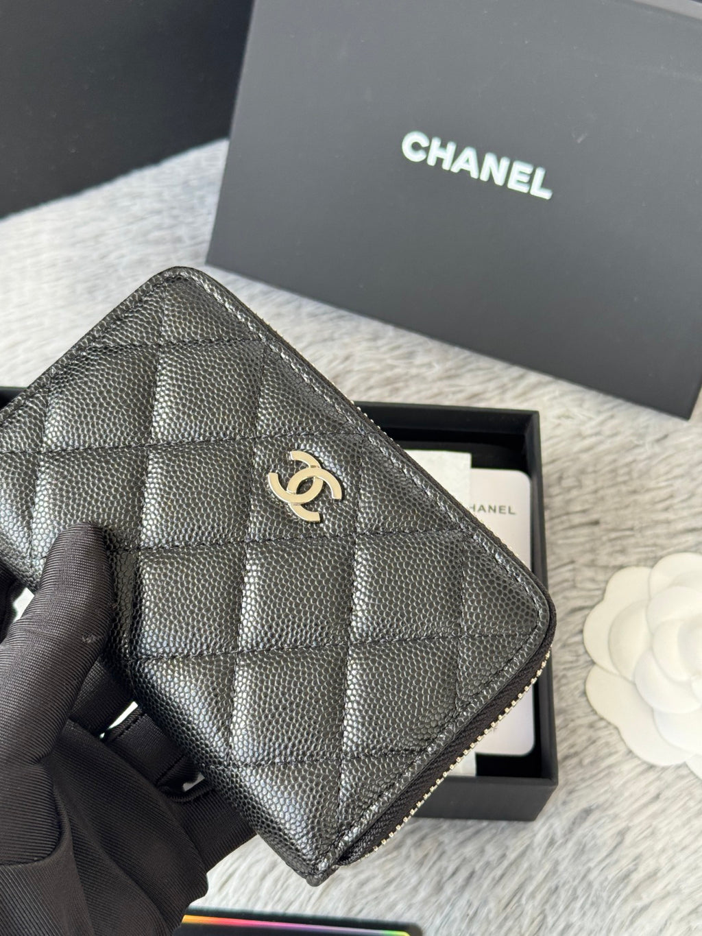 Chanel quilted small bag with zip closure and chain strap, dark black, close-up front.