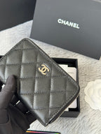 Chanel quilted small bag with zip closure and chain strap, dark black, close-up front.