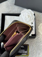 Small bag with maroon lining, gold zipper pull, and interior pocket